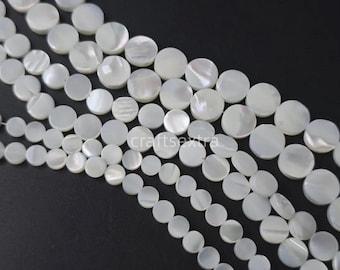Peut inclure: Plusieurs rangs de perles en nacre blanche de forme circulaire plate. Les perles présentent une finition lisse et irisée avec des variations naturelles de lustre et de texture. Le texte craftsextra est visible au centre de l'image.