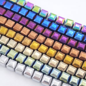 Può includere: Un filo di perline quadrate iridescenti in un arcobaleno di colori, tra cui argento, oro, rame, viola, blu e verde.