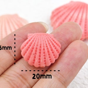 K&ouml;nnte beinhalten: Rosa Plastikperle in Muschelform mit einer L&auml;nge von 20 mm und einer Breite von 16 mm.