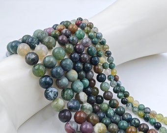 May include: A strand of green, brown, and white agate beads. The beads are round and have a smooth, polished finish.