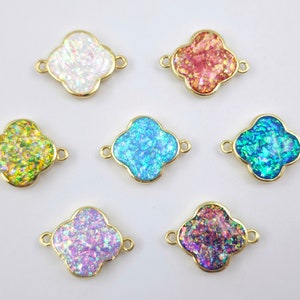 Puede incluir: Siete conectores dorados en forma de trébol con centros iridiscentes en varios colores, incluyendo blanco, rojo, azul, verde y morado. Cada conector tiene dos bucles para fijar. Ideal para la creación de joyas.