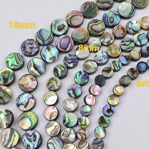 May include: Assortment of iridescent abalone shell beads in three sizes: 10mm, 8mm, and 6mm. The beads are round and have a smooth, polished finish.