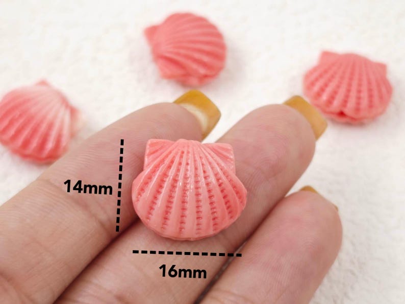 K&ouml;nnte beinhalten: Rosa Plastik-Muschel-Anh&auml;nger, 14 mm breit und 16 mm lang. Diese kleinen Muscheln sind perfekt, um Schmuck, Bastelarbeiten und anderen Projekten einen Hauch von Verspieltheit zu verleihen.