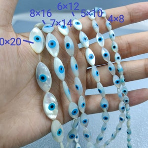 May include: A strand of white oval-shaped beads with blue and black evil eye designs. The beads are strung on a clear thread and are available in various sizes, including 4x8, 5x10, 6x12, 7x14, 8x16, and 10x20.