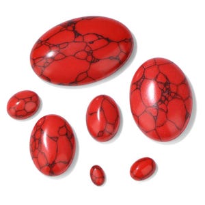 K&ouml;nnte beinhalten: Eine Sammlung roter, oval geformter Edelsteine mit dunklen Adern. Die Steine variieren in der Gr&ouml;&szlig;e, von klein bis gro&szlig;, und sind auf wei&szlig;em Hintergrund angeordnet. Die polierten Steine haben eine gl&auml;nzende Oberfl&auml;che.