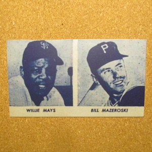 May include: A vintage baseball card featuring two baseball players. Willie Mays is on the left wearing a blue and white baseball cap with the letter "S" on it. Bill Mazeroski is on the right wearing a blue and white baseball cap with the letter "P" on it.