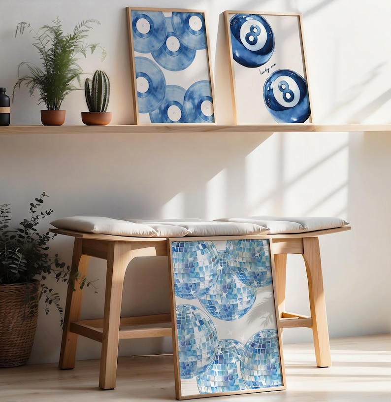 Puede incluir: Tres impresiones de acuarela enmarcadas con un esquema de color azul y blanco. Las impresiones presentan una bola de billar azul n&uacute;mero ocho, una bola de billar azul n&uacute;mero ocho con el texto "lucky me" y un patr&oacute;n de c&iacute;rculos azules superpuestos.