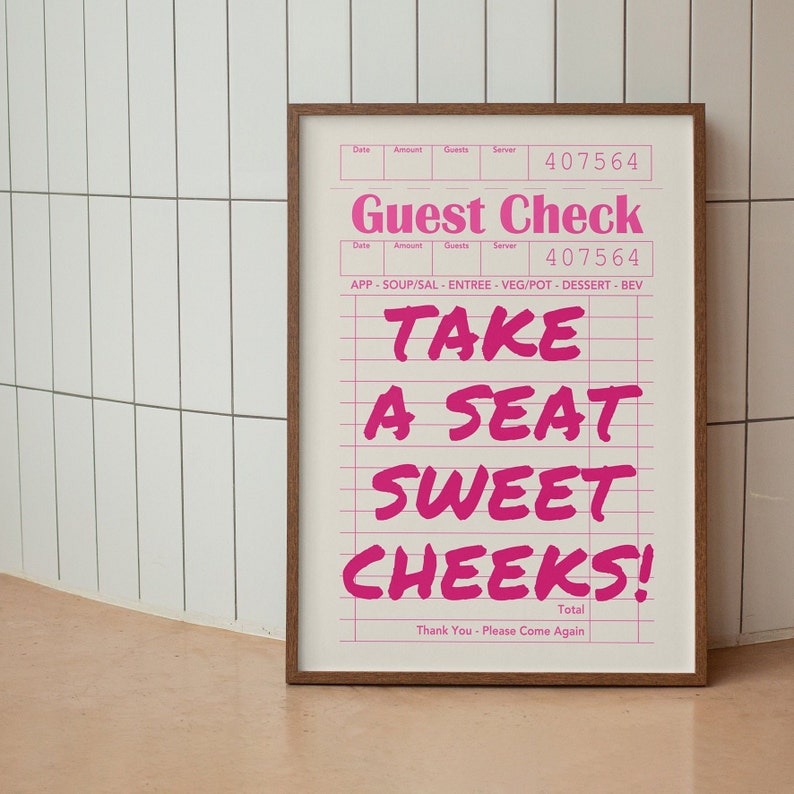 K&ouml;nnte beinhalten: Ein gerahmter Druck mit einem rosa und wei&szlig;en Design. Der Druck zeigt einen Restaurant-G&auml;stedurchlauf mit dem Text "Guest Check" und "Take a Seat Sweet Cheeks!" in rosa Schrift. Der Text "Thank You - Please Come Again" ist unten auf dem Druck gedruckt.