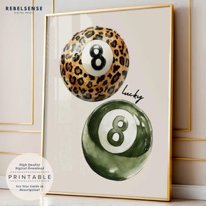 May include: Two 8-ball pool balls, one with a leopard print pattern and the other with a green and white pattern. The word "lucky" is written in cursive above the green ball.