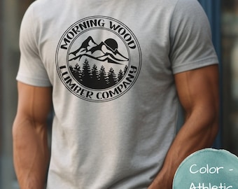 May include: A gray t-shirt with a black circular logo that says "Morning Wood Lumber Company" and features a mountain range with a sun and trees.