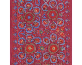 May include: A red fabric wall hanging with a floral pattern embroidered in blue, green, orange, and yellow thread.
