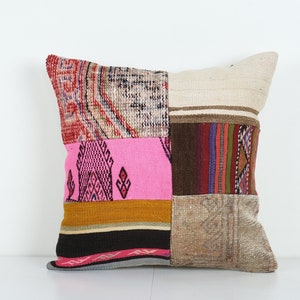 Puede incluir: Una funda de cojín de patchwork con una variedad de colores y patrones, incluyendo rosa, marrón, beige y rojo. La funda de cojín está hecha de materiales reciclados y tiene un aspecto único y hecho a mano.