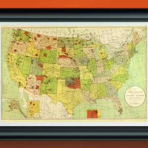 May include: Framed vintage map of the United States, showcasing states in various colors. The map includes a circular inset with text and is set against a white background within a black frame. The map is a historical piece.