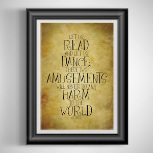 May include: A framed print with a black frame features a quote by Voltaire: "Let us read and let us dance; these two amusements will never do any harm to the world." The text is in black on a sepia-toned background.