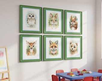 May include: Six framed watercolor prints of woodland animals, including an owl, rabbit, squirrel, deer, fox, and bear. Each print is in a green frame with a white mat, displayed on a white wall. The room also has a blue table and red chairs.