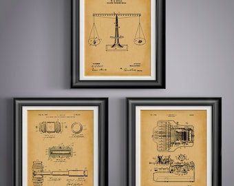 May include: Three vintage patent prints in black and white, framed in black wood. The top print shows a scale design with the text "W.B. Guild, Balloon Weighing Scale". The middle print shows a design for a "Solar Motor with Magnetic Brake and Friction Clutch" and the bottom print shows a design for a "Typewriter".