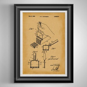 May include: Framed patent print featuring a detailed technical drawing of a device, dated February 2, 1943. The sepia-toned print includes multiple diagrams and the inventor's signature, offering a vintage aesthetic. The print is encased in a black frame.