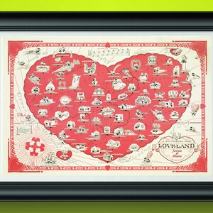 May include: Framed print of a pictorial map of Loveland, featuring a heart-shaped design in red and white. The map includes various illustrations and the text "A Pictorial Map Loveland" with the names "Jennie & Blaire".