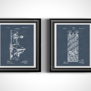 May include: Two framed vintage telephone patent prints. The prints are in black frames with white matting. The prints are on a dark blue background. One print shows a wall phone, and the other shows a switchboard.