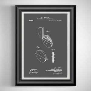 May include: Framed patent illustration of a pocket box for violin strings, dated November 27, 1877. The diagram is in white on a dark gray background, with detailed technical drawings and text. The frame is black.