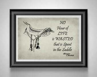 May include: Framed print featuring a detailed illustration of a horse saddle in black and white. The print includes the quote "NO Hour of LIFE is WASTED that is Spent in the Saddle" by Winston Churchill, set against a beige background.