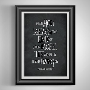 May include: Black and white typography quote on a chalkboard background in a black frame. The quote reads "When you reach the end of your rope, tie a knot in it and hang on." - Franklin D. Roosevelt