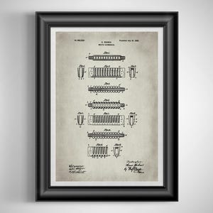 May include: Framed vintage print of a harmonica patent. The black and white illustration shows detailed diagrams of the instrument's components. The print includes text indicating the patent date and inventor's name, set against a beige background.