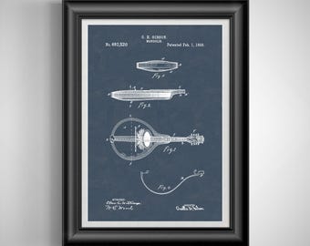 May include: Framed print of a vintage mandolin patent illustration. The blueprint-style drawing is in white on a navy blue background. The text includes "O. H. Gibson, Mandolin, Patented Feb. 1, 1898" and "No. 692,520". The frame is black.