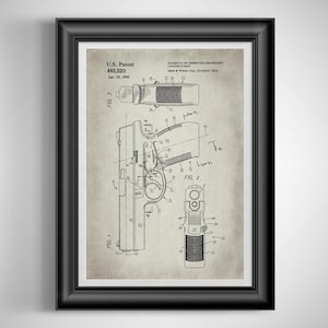 May include: Framed patent print of a handgun, featuring detailed technical drawings. The print includes diagrams of the firearm's components, labeled with numbers and arrows. The text "U.S. Patent 692,520" is visible, along with the date "Apr. 18, 1995".