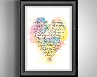 May include: A framed print with a black frame features a watercolor heart filled with colorful hues. The heart shape contains handwritten text from 1 Corinthians 13:4-8, a passage about love. The background is white.