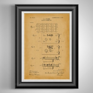 May include: Framed vintage patent print of a safety deposit box, dated September 8, 1903. The print features detailed diagrams and technical drawings in black ink on a tan background. The frame is black.