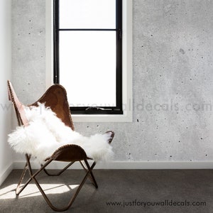 May include: A brown leather butterfly chair with a white sheepskin throw on top. The chair is in a room with a concrete wall and a window. The text "www.justforyouwalldecals.com" is visible at the bottom of the image.