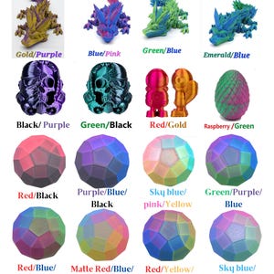 May include: A display of 3D-printed items in dual and tri-colour schemes. The image features dragon figurines, skull-shaped figures, small robot-like figures, and geometric spheres. Colours include gold/purple, blue/pink, green/blue, and red/black.