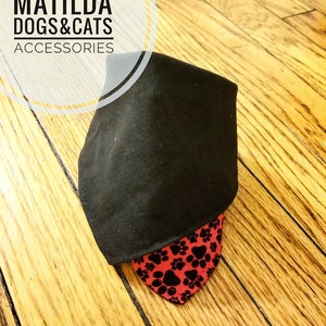 May include: Black bandana with red paw print fabric underneath. The bandana is folded in half and the text "MATILDA DOGS & CATS ACCESSORIES" is visible in the top left corner.
