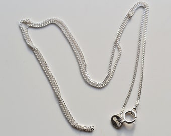 May include: A silver chain necklace with a lobster clasp closure.