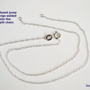 May include: A silver chain necklace with a lobster clasp. The chain is made of small, oval links. The text "Closed jump rings soldered onto the split chain" is visible in the image.
