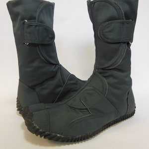 Op de afbeelding: Een paar donkergrijze canvas laarzen met een rits en een klittenbandsluiting. De laarzen hebben een dikke, zwarte rubberen zool met een profiel.