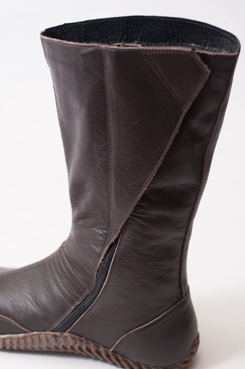 Puede incluir: Botas de cuero marr&oacute;n con cremallera en la parte posterior y suela texturizada.