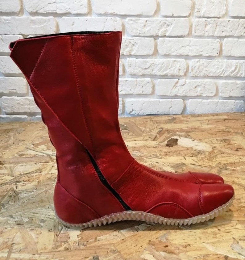 Pu&ograve; includere: Stivali in pelle rossa con cerniera sul retro e suola testurizzata.