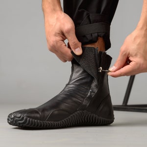 May include: Black leather ankle boots with a zipper on the side and a textured rubber sole.
