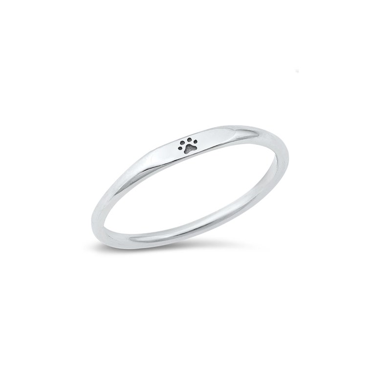 May include: A silver ring with a small paw print design.