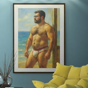 Op de afbeelding: Een ingelijst kunstwerk met een gespierde persoon in wit en rood badgoed, bij de zee. Het kunstwerk hangt aan een blauwe muur, aangevuld met een gele accentstoel, een glazen salontafel en een decoratieve vaas.