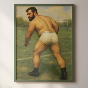 Puede incluir: Un cuadro enmarcado representa una figura musculosa en calzoncillos blancos sobre un campo verde, como si jugara al rugby. La obra está enmarcada en un borde verde y cuelga de una pared color crema. Una estantería de madera con una planta y un cuenco está en primer plano.