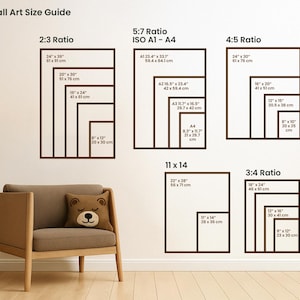 Puede incluir: Gu&iacute;a de tama&ntilde;os de arte mural con varias proporciones, incluyendo 2:3, 5:7, 4:5, 11x14 y 3:4. Cada proporci&oacute;n muestra m&uacute;ltiples tama&ntilde;os de marco en pulgadas y cm. Un sill&oacute;n marr&oacute;n y un coj&iacute;n con forma de oso en primer plano.