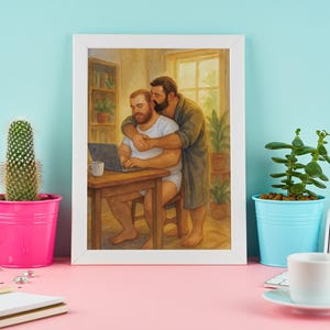 Puede incluir: Una impresión artística enmarcada representa a dos hombres en un interior cálido. Uno está sentado en un escritorio de madera con un portátil, el otro lo abraza por detrás. La obra de arte está sobre una pared azul claro.