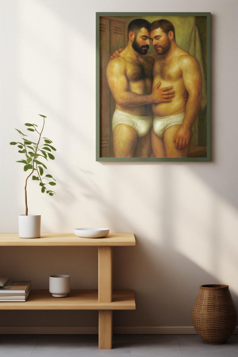 Puede incluir: Una pintura enmarcada representa a dos hombres en calzoncillos blancos abraz&aacute;ndose. La obra de arte, en un marco verde, utiliza una paleta de colores c&aacute;lidos para los tonos de piel de los hombres y el fondo. La pintura se exhibe en una pared blanca, con una estanter&iacute;a de madera y objetos decorativos en primer plano.