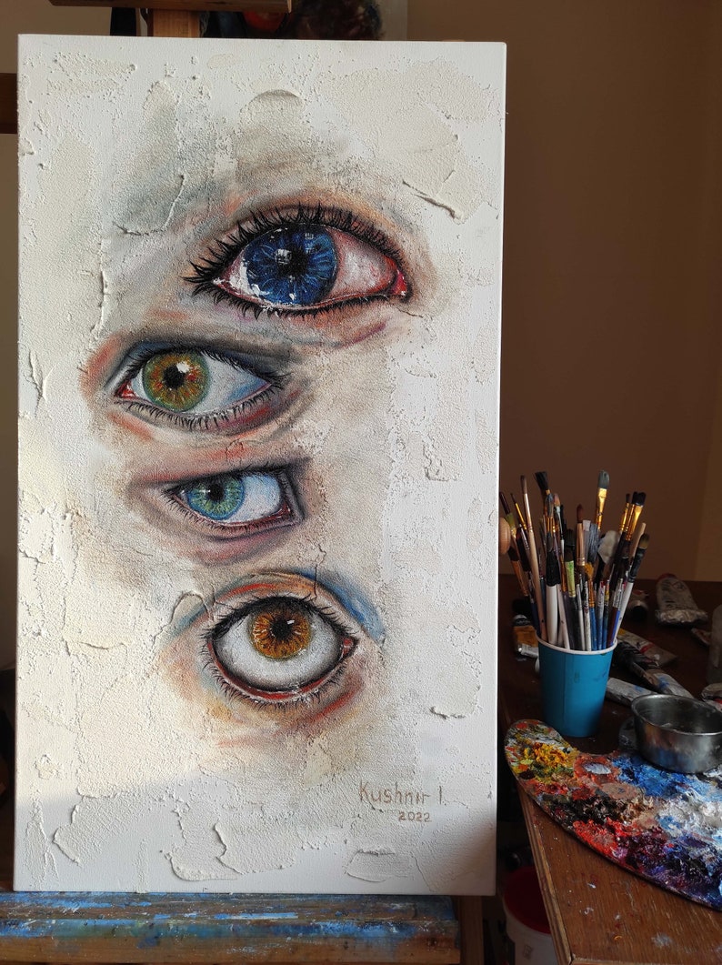 Puede incluir: Una pintura sobre lienzo blanco con cuatro ojos pintados en ella. Los ojos son de diferentes colores y tienen diferentes expresiones. La pintura est&aacute; firmada "Kushnir I. 2022" en la esquina inferior derecha.