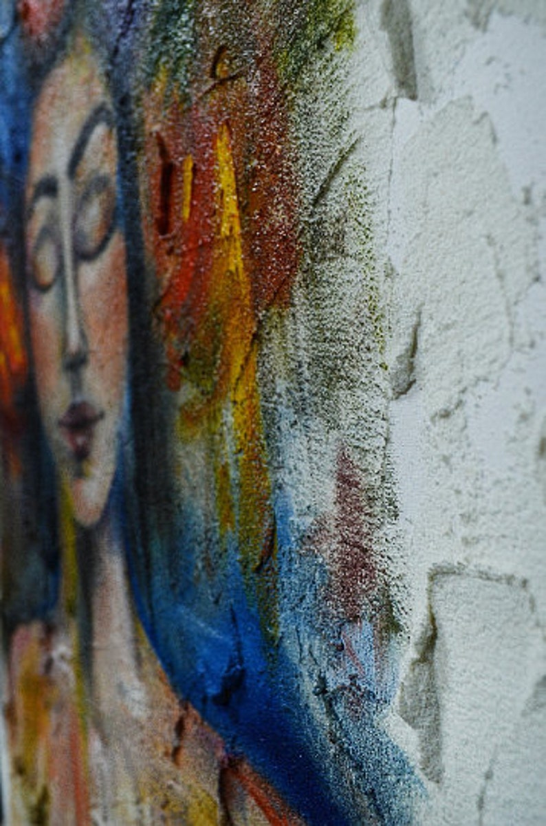 Pu&ograve; includere: Dipinto astratto di un viso di donna con vernice blu, gialla, rossa e bianca. Il viso della donna &egrave; parzialmente oscurato dalla vernice.