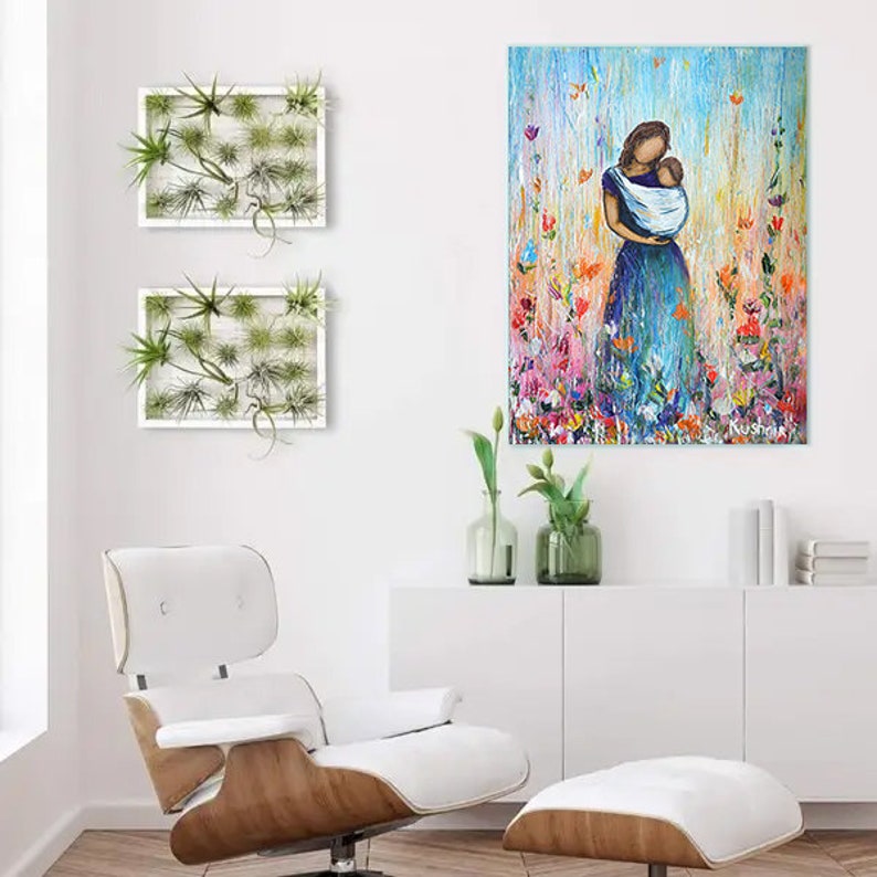 May include: A painting of a woman holding a baby in a field of flowers. The woman is wearing a blue dress and the baby is wearing a white shirt. The painting is done in a colorful style with a lot of detail.