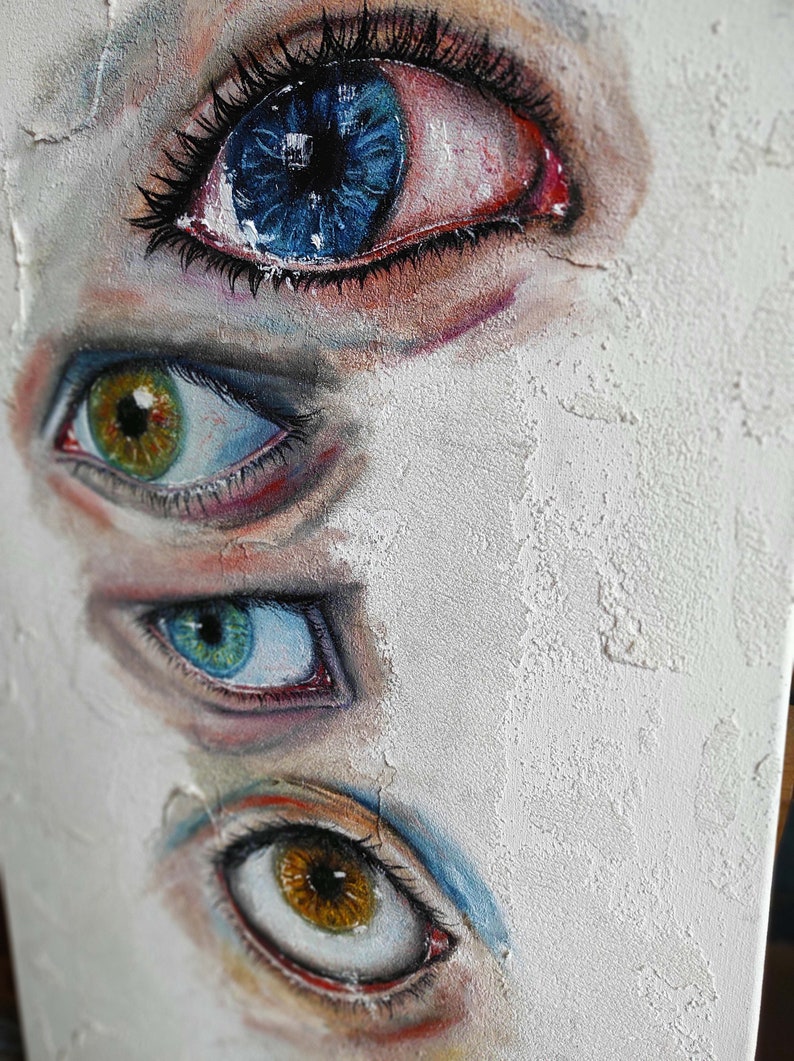 Puede incluir: Una pintura de cuatro ojos, cada uno con un iris de color diferente. Los ojos est&aacute;n pintados en un estilo realista, con detalles como pesta&ntilde;as y vasos sangu&iacute;neos. El fondo es una superficie blanca texturizada.